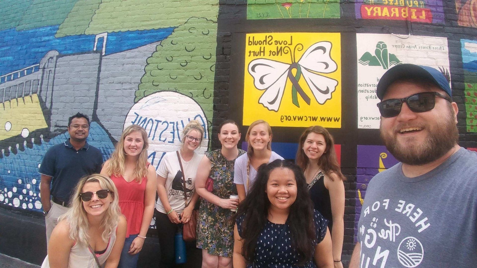 Group photo of Cohort two fellows in front of a mural