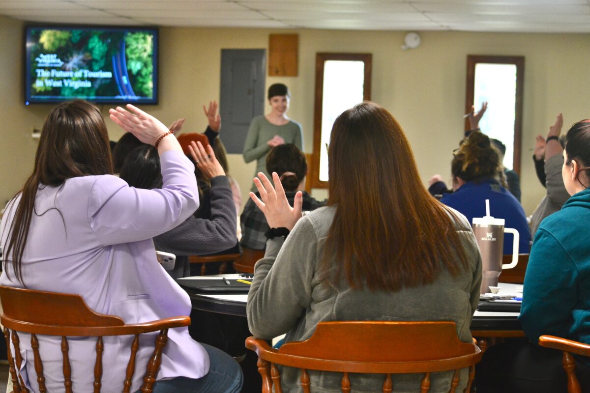 Fellows in a session raising their hands